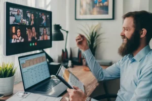 Business owner on a video call with a remote global team while reviewing hiring spreadsheets